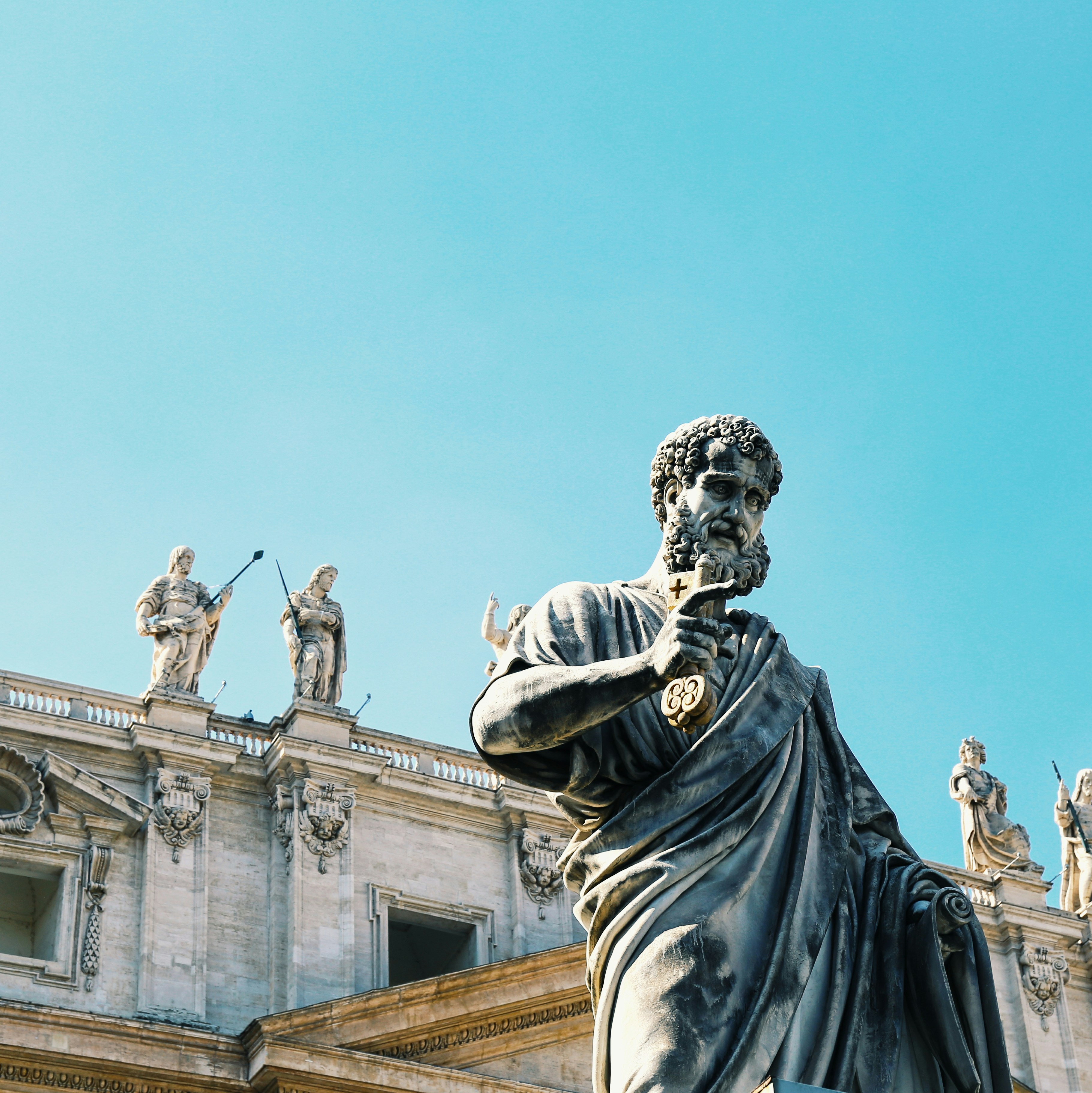 man in robe statue under blue sky during daytime